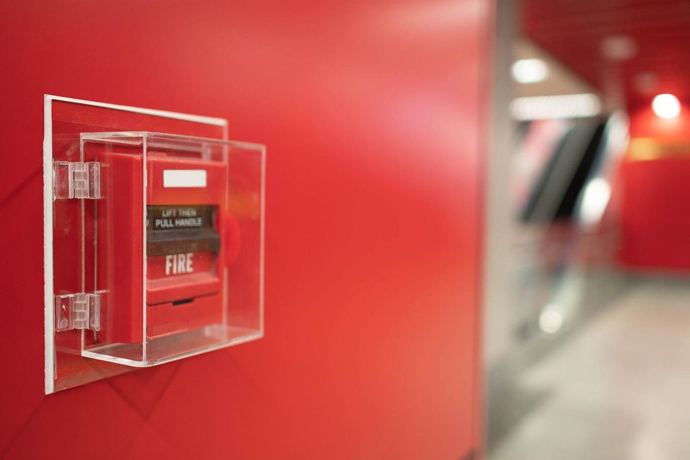 Red fire alarm pull station on a wall
